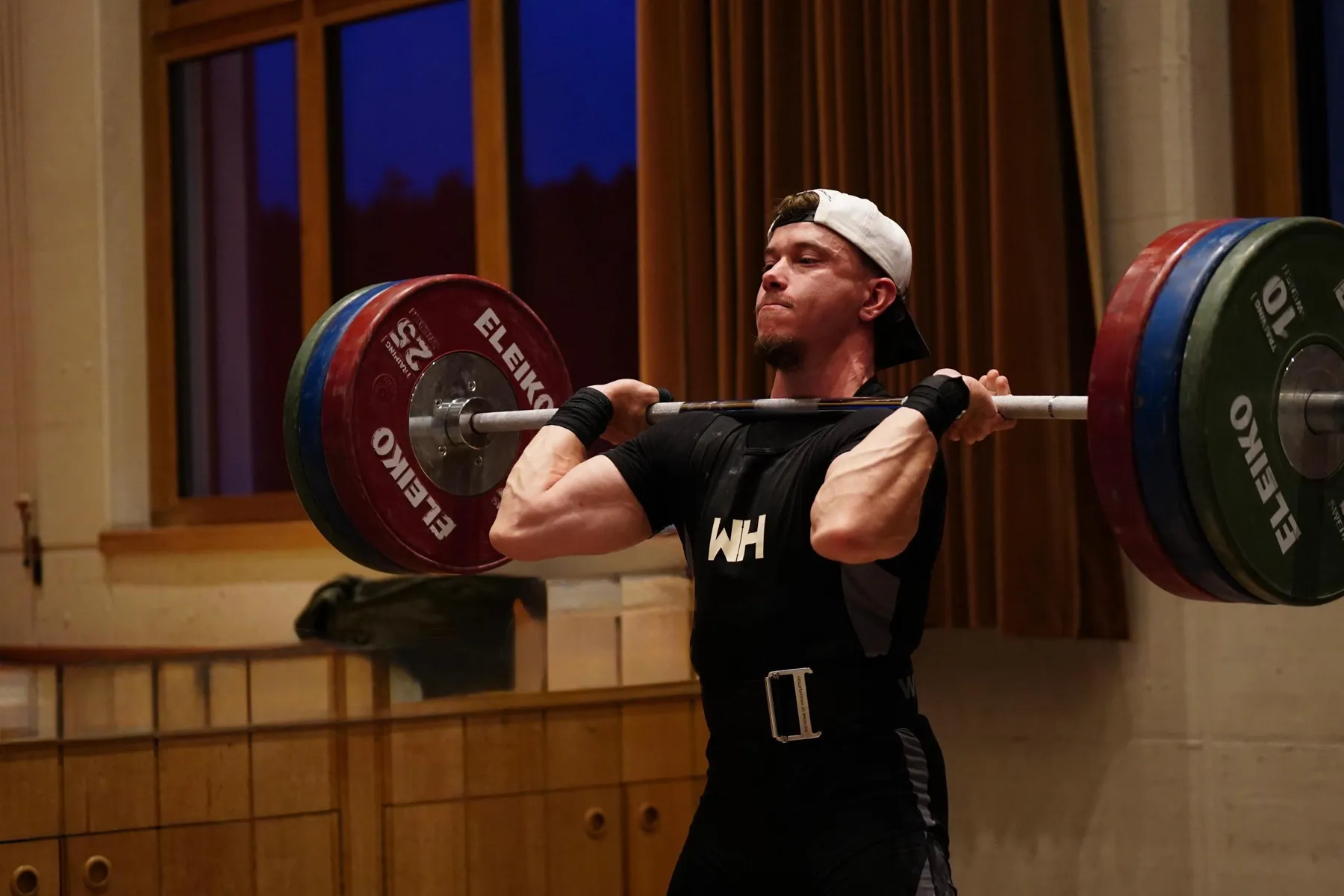 Patrick Cornes front squatting in a weightlifting gym